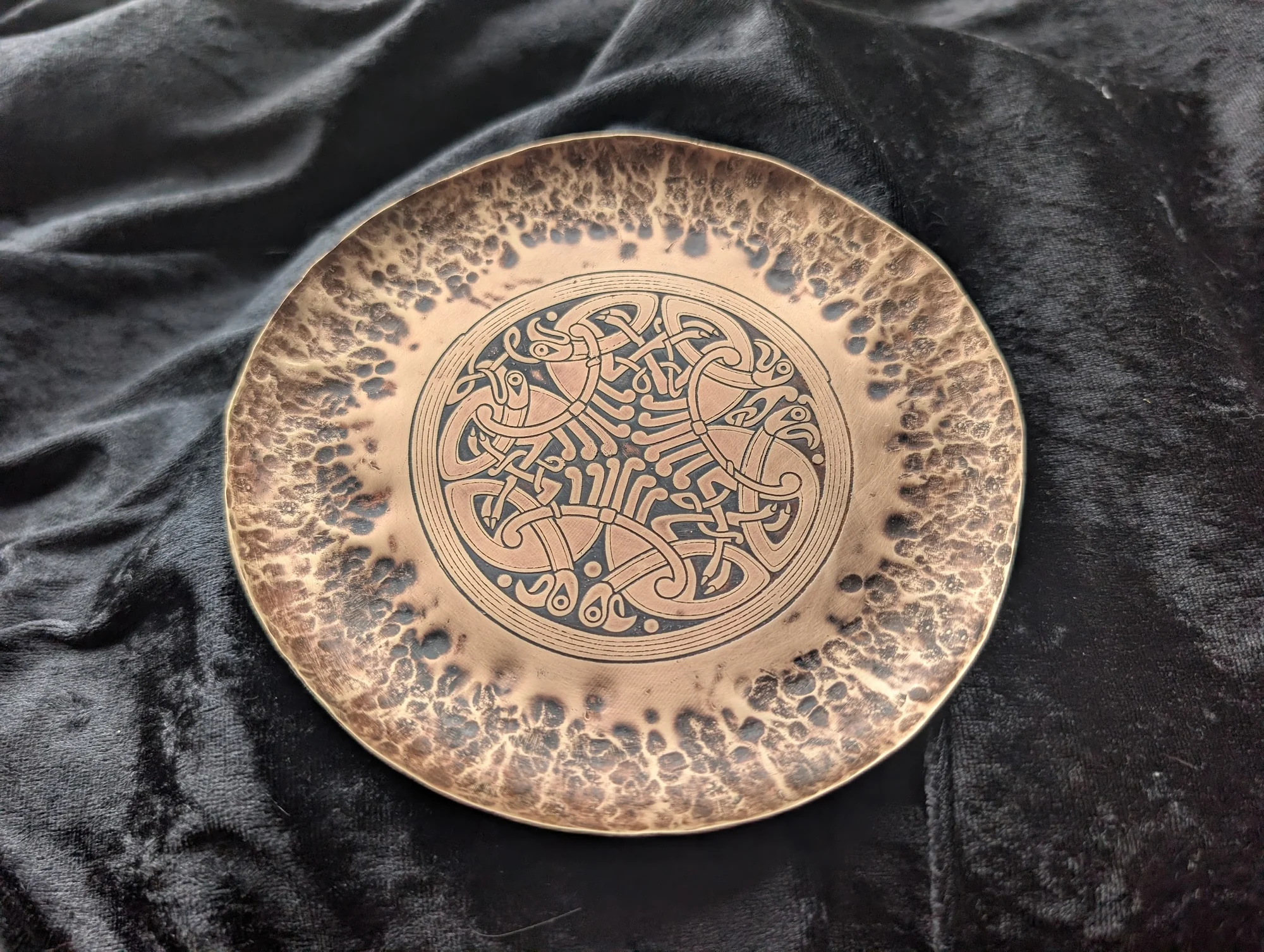 Hammered bronze plate etched with interlaced animal knotwork inspired by the Book of Durrow by BorboroForge