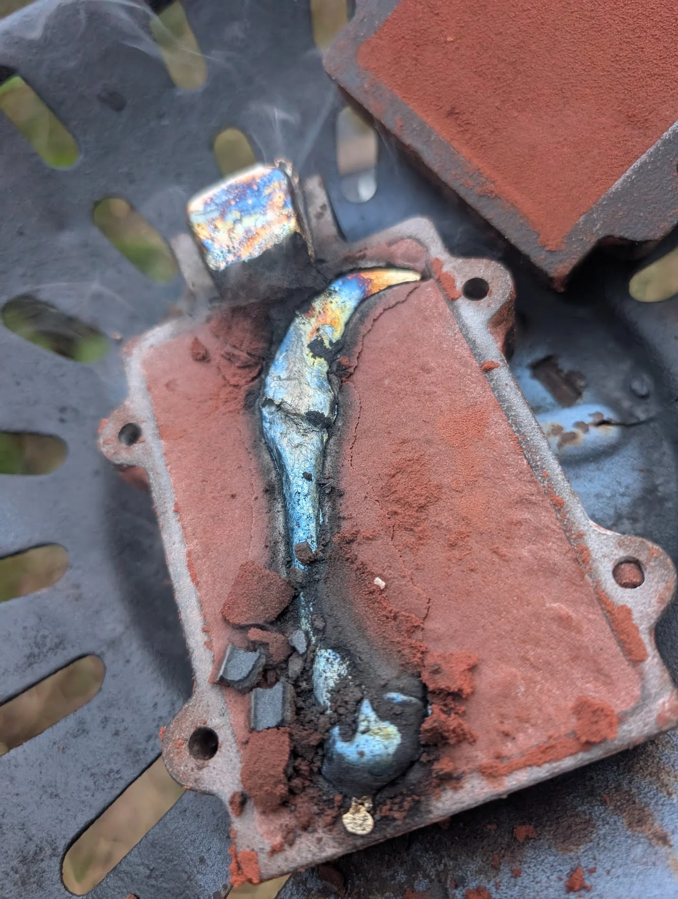 Freshly poured metal ritual claw resting in a red sand casting mold at BorboroForge